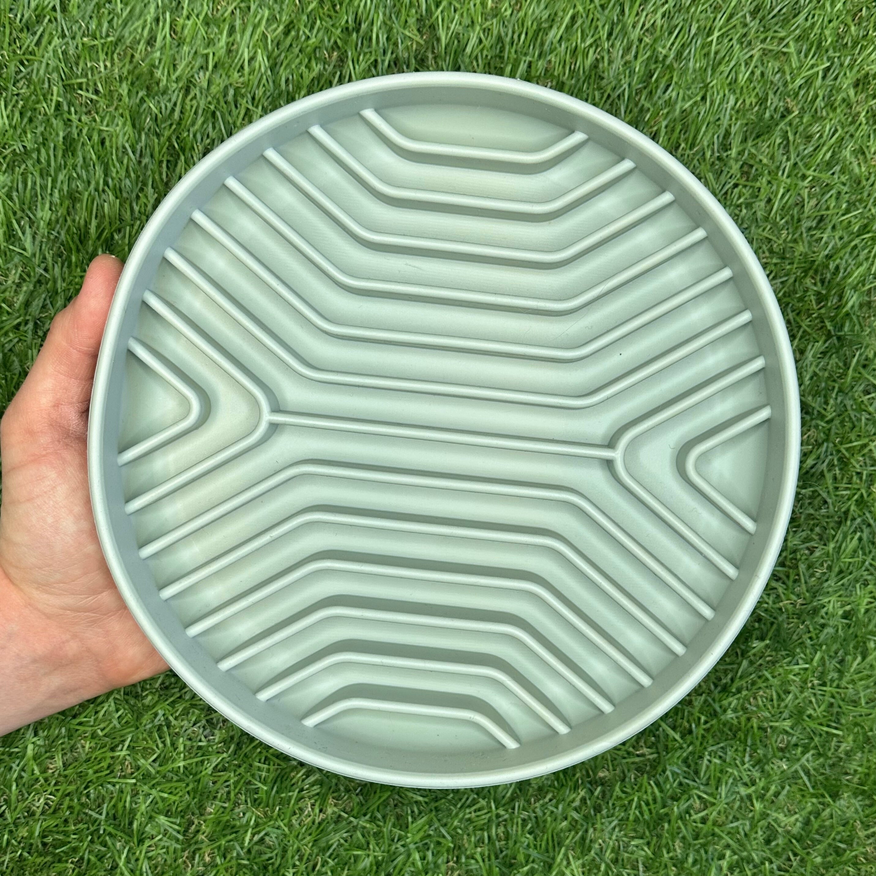 Empty Better Bowl slow feeder held outdoors over grass – durable silicone dog bowl for healthy eating.